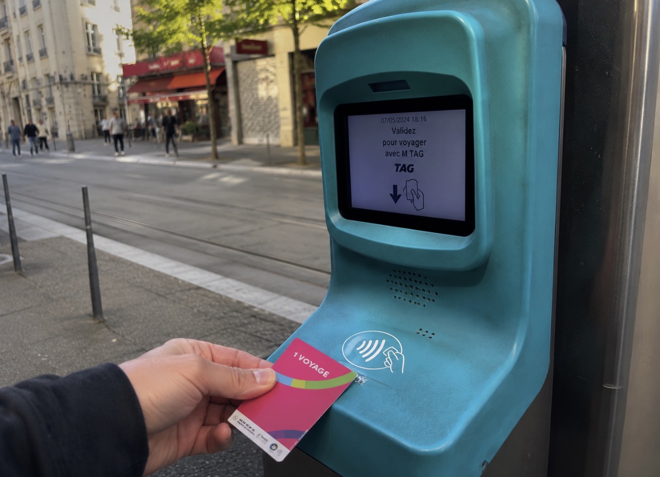 Étudiants attendant un tram à Grenoble à l’approche de la rentrée universitaire, illustration des nouveaux tarifs de transport étudiant.