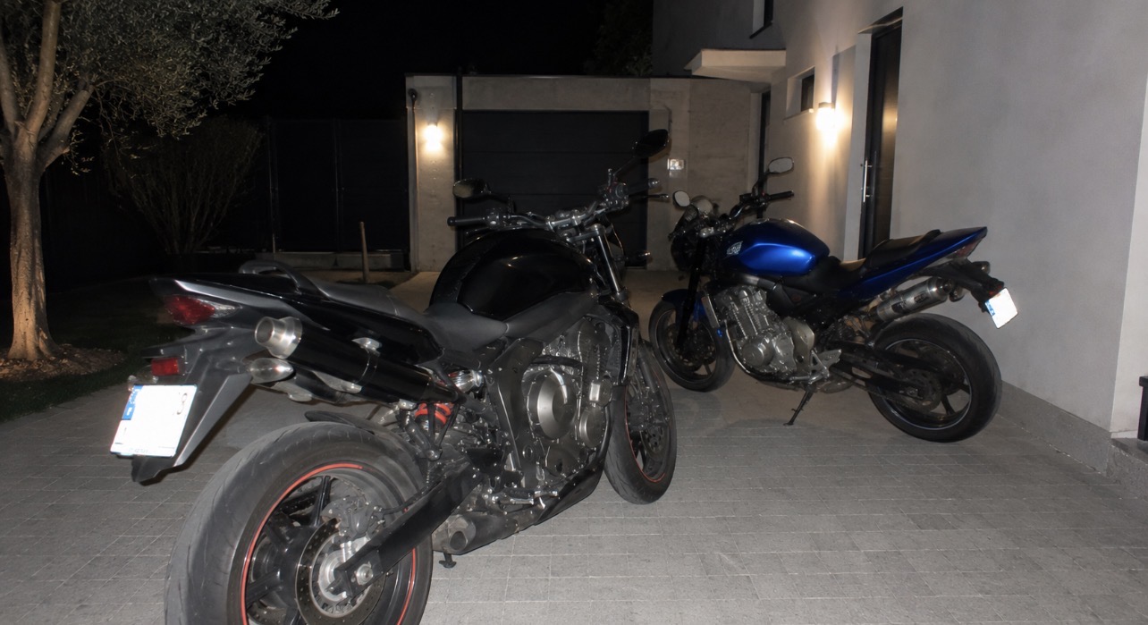 Deux motos stationnées devant des habitations à Saint-Maurice-l’Exil, illustrant une affaire de vol survenue après un conflit de voisinage.