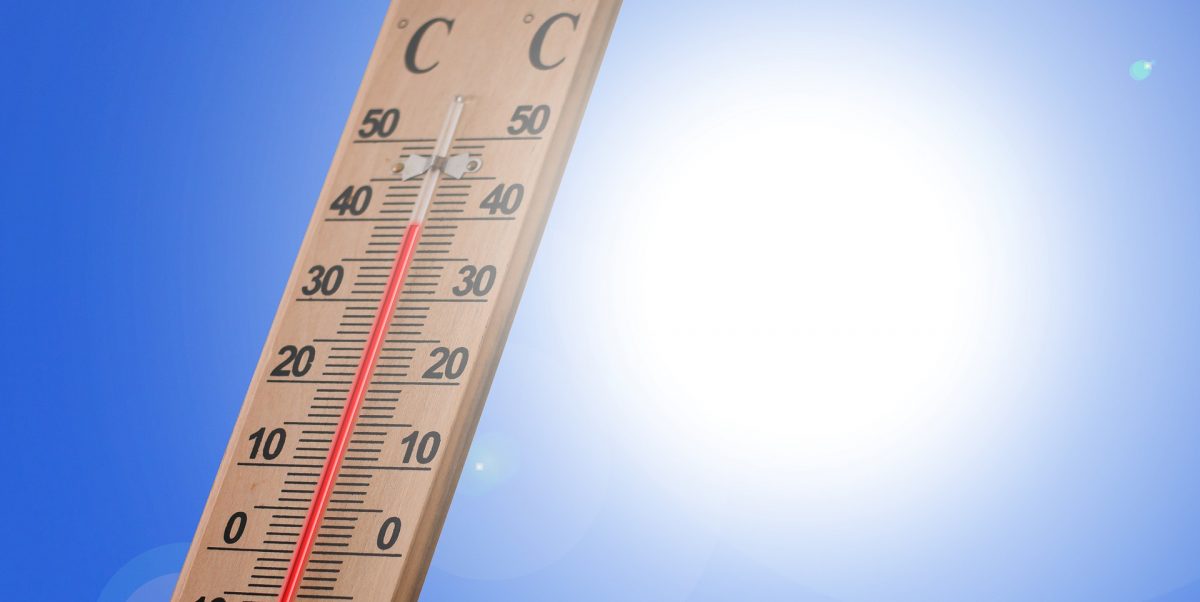 Un thermomètre affichant 37 °C devant un ciel bleu ensoleillé, sous une forte chaleur estivale.