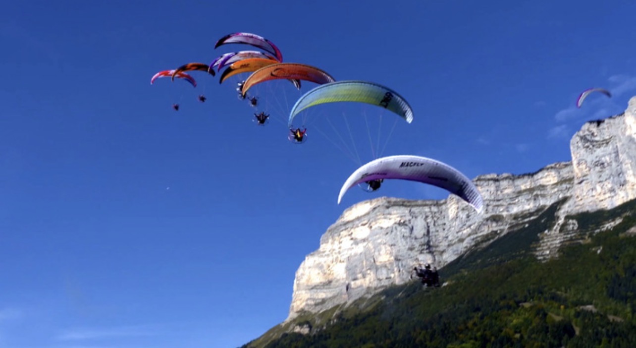 Site de la Coupe Icare sur le Plateau-des-Petites-Roches avec des deltaplanes et des parapentes dans le ciel.