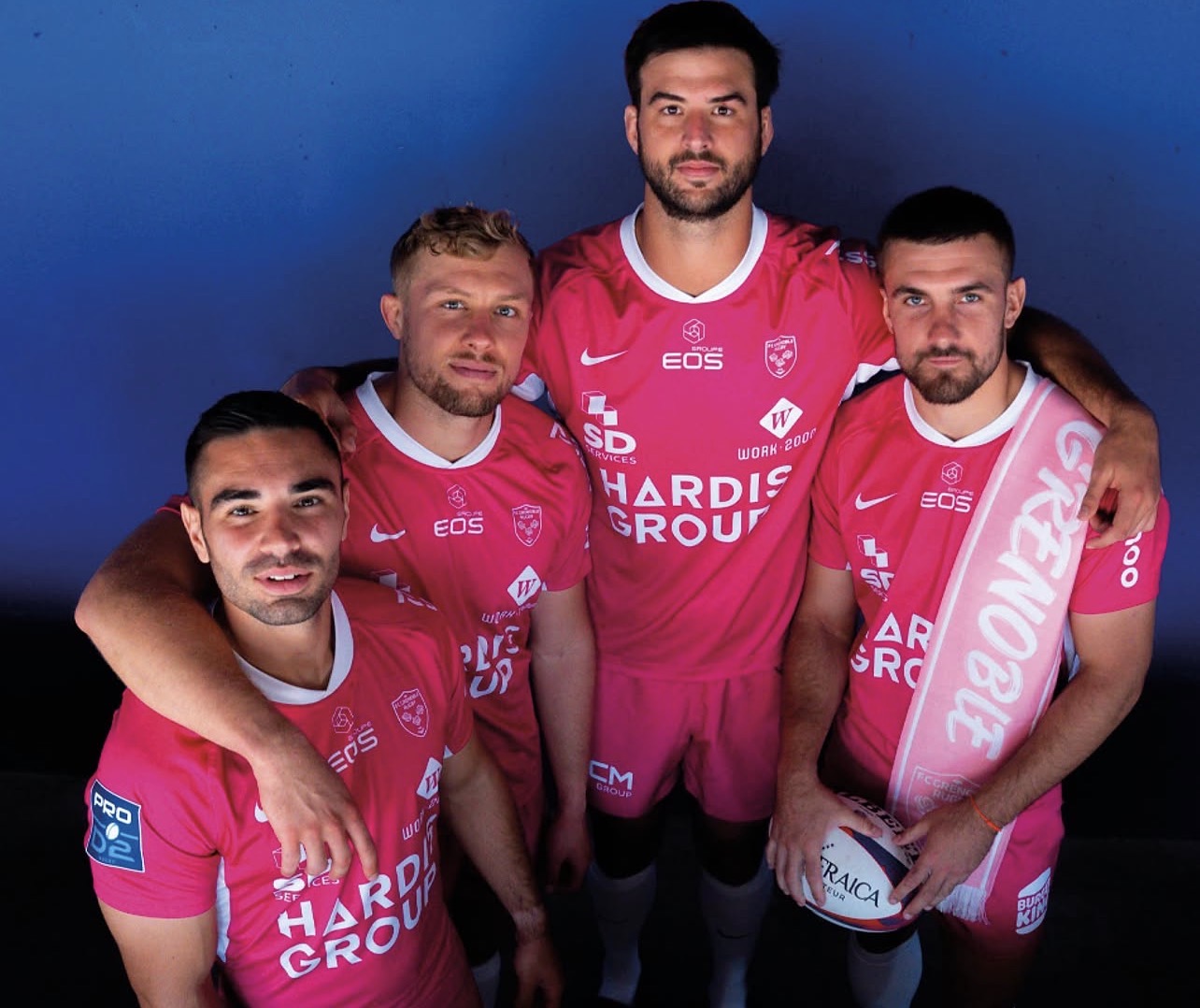 Des joueurs du FC Grenoble Rugby posent avec le maillot entièrement rose créé pour les matches à domicile d’octobre au Stade des Alpes.